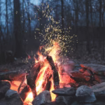 Camp fire symbolizing the show Alone and the lessons we can learn from survival experts and apply to our own personal finance lives.