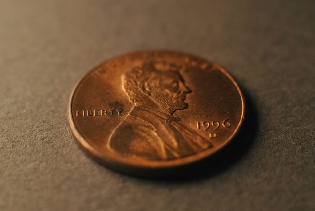 A penny sitting on top of a table representing the power of compound interest when you invest early and often.