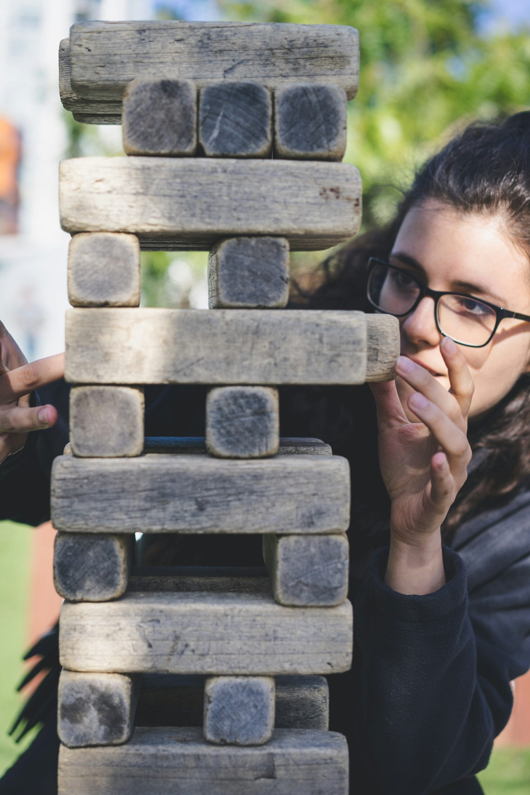 woman playing with wooden blocks illustrating the cost of investing is risk.